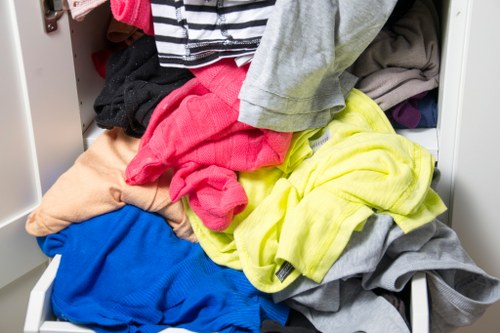 Two operatives carrying bulky furniture down narrow stairs